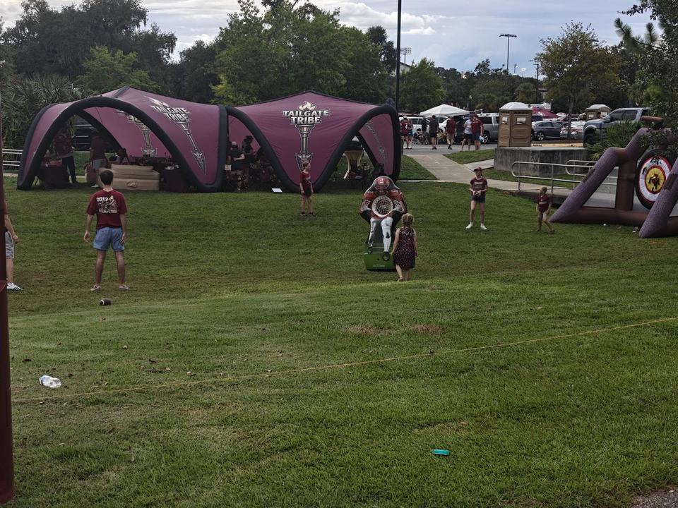 The canopies, tomahawk toss, and QB dummy with fans on the grass