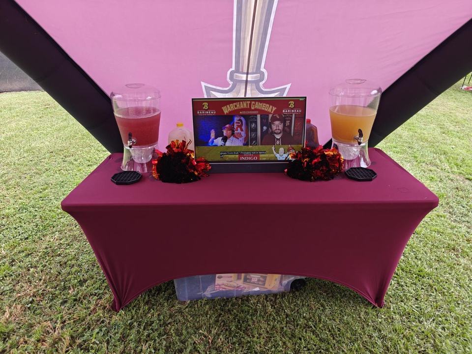Garnet and gold punch dispensers with Warchant Gameday on the TV