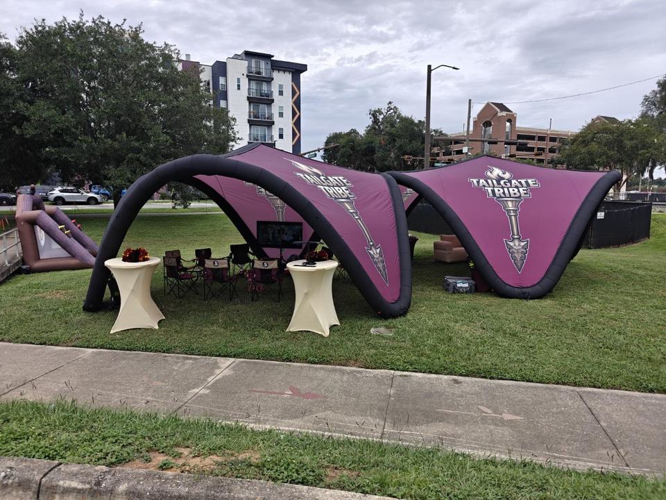 The two Tailgate Tribe canopies from the sidewalk on Pensacola Street